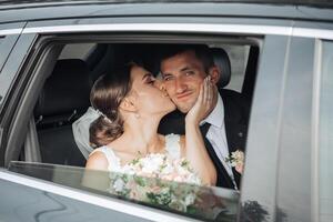 A bride and groom are kissing in a car photo