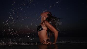 ein beschwingt dynamisch Wasser Spritzen beim Nacht im ein Strand Rahmen video