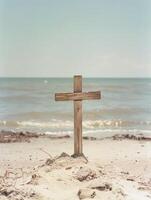 A wooden cross on the beach with blue sea and sky background photo