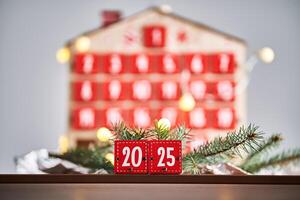 Christmas Advent calendar in the shape of a house with boxes making up the number 2025. photo