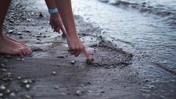 Two hands gracefully draw a heart on the sand by the waters edge, each stroke symbolizing love. As waves gently approach heart remains a testament to the bond shared, a moment of serene connection. video