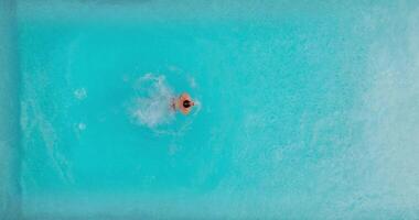 Aerial view as a man dives into the pool and swims. video