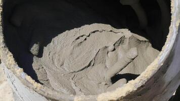 Fresh cement mixture in container. A detailed shot of a freshly mixed batch of cement inside a large container, ready for use in construction. video