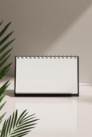 A blank desk calendar standing on a table with a palm leaf on either side photo