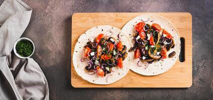 Tortilla with mushrooms, tomatoes, ricotta and onions on a board top view web banner photo