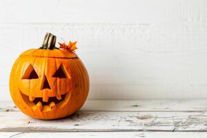 Carved Halloween pumpkin on rustic white background photo