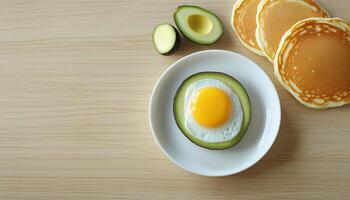 Pancake with egg fried no oil, avocado fruit slice on white plate in table flat lay photo