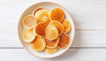 Mini pancakes simple food for breakfast on white plate, flat lay white background photo