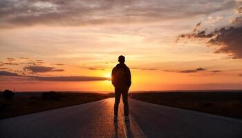 Lonely young man silhouette at sunset, copy space, tourist stand alone by road with epic sky in background. photo