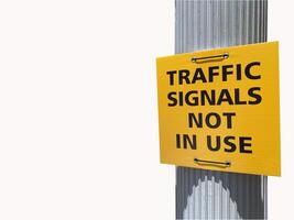 Traffic signal not in use sign in square yellow board on silver pole isolated on white background photo