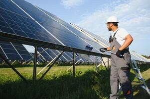 A young Indian cleaning service worker cleans solar panels photo