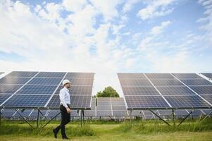 The solar farm, solar panel with engineer check the operation of the system, Alternative energy to conserve the worlds energy, Photovoltaic module idea for clean energy production. photo