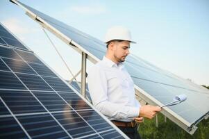 The solar farm, solar panel with engineer check the operation of the system, Alternative energy to conserve the worlds energy, Photovoltaic module idea for clean energy production. photo