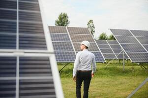 The solar farm, solar panel with engineer check the operation of the system, Alternative energy to conserve the worlds energy, Photovoltaic module idea for clean energy production. photo