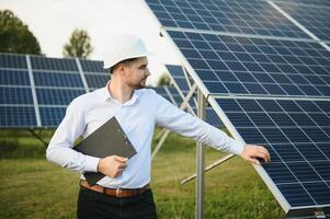 The solar farm, solar panel with engineer check the operation of the system, Alternative energy to conserve the worlds energy, Photovoltaic module idea for clean energy production. photo