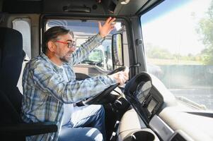 Shot of mad and nervous professional truck driver having arguing in traffic and yelling at someone. Transportation traffic problems photo