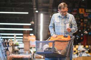 Minded man viewing receipts in supermarket and tracking prices photo