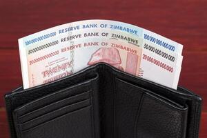 Old Zimbabwean banknotes in the black wallet photo