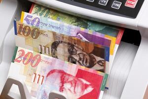 Israeli new shekel in the counting machine photo