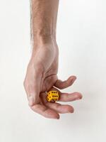 Hand holding yellow die. minimalist concept of chance and decision-making photo