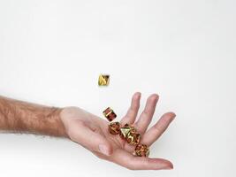 Hand tossing colorful dice against white background photo