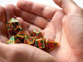 Colorful dungeons and dragons dice set held in hands for tabletop gaming enthusiasts photo
