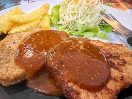 Closeup and crop Pork Steak with French Fries and Salad photo