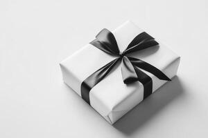 A neatly wrapped white gift box with a black ribbon, symbolizing celebration or surprise. photo