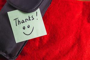 A soft black box on a red background with a turquoise thank you label photo