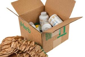 Lviv Ukraine 08.17.24 open iHerb box with vitamins on a white background photo