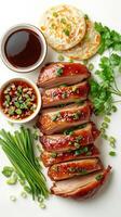 Roasted duck slices with glaze, green onions, and parsley on a white background photo