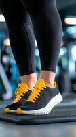 Close-up of Runner's Legs in Black Leggings and yellow-black sneakers, on Treadmill photo