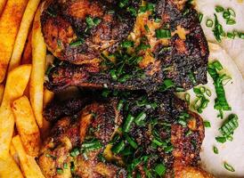 Juicy grilled pork chops with fries on plate photo