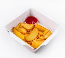 Crispy potato wedges in takeout box with ketchup photo