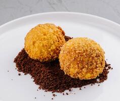 Gourmet truffles on white plate with cocoa dusting photo