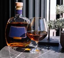 Elegant cognac pour with bottle on classy bar counter photo