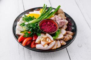 Delicious appetizers platter with horseradish sauce and salo on white table photo