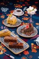 Delicious cakes and pastries arranged on plates with coffee and marshmallows on a table photo
