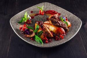 Roasted duck breast with pear and red currant sauce on plate photo