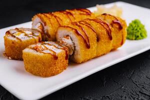 Delicious tempura maki sushi rolls being served on white plate photo