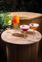 Four colorful cocktails resting on a table in a tropical setting photo