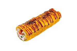 Sushi roll is lying on a white surface, covered in sauce and sesame seeds photo