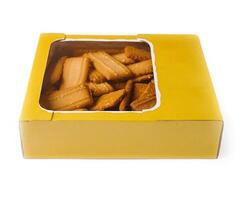 Rectangular shortbread cookies with sesame seeds in yellow cardboard box photo