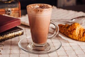 Steaming hot chocolate enjoying peaceful morning with books and croissant photo