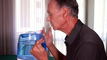 Slow Motion of a Man using an air humidifier to help him breath in dry weather and clear up his sinus video