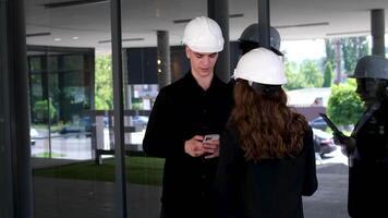 Female carpenter apprentice with her colleague. Guy and girl at a construction site, builders foreman video