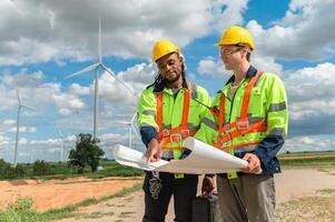 Two men in yellow vests are standing in a field, looking at a piece of paper photo