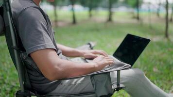 Programmer is writing code.Development, graph analysis and typing on a laptop, typing on laptop keyboard, work stress, working online, anxiety, working in a park, office syndrome. video