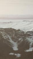 large snow patch left over on the volcanic rock field of a mountain in summer video