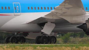 Close-up shot of the plane taxiing, view of the chassis and wing, engines. A huge wide-body passenger airliner on a taxiway video
